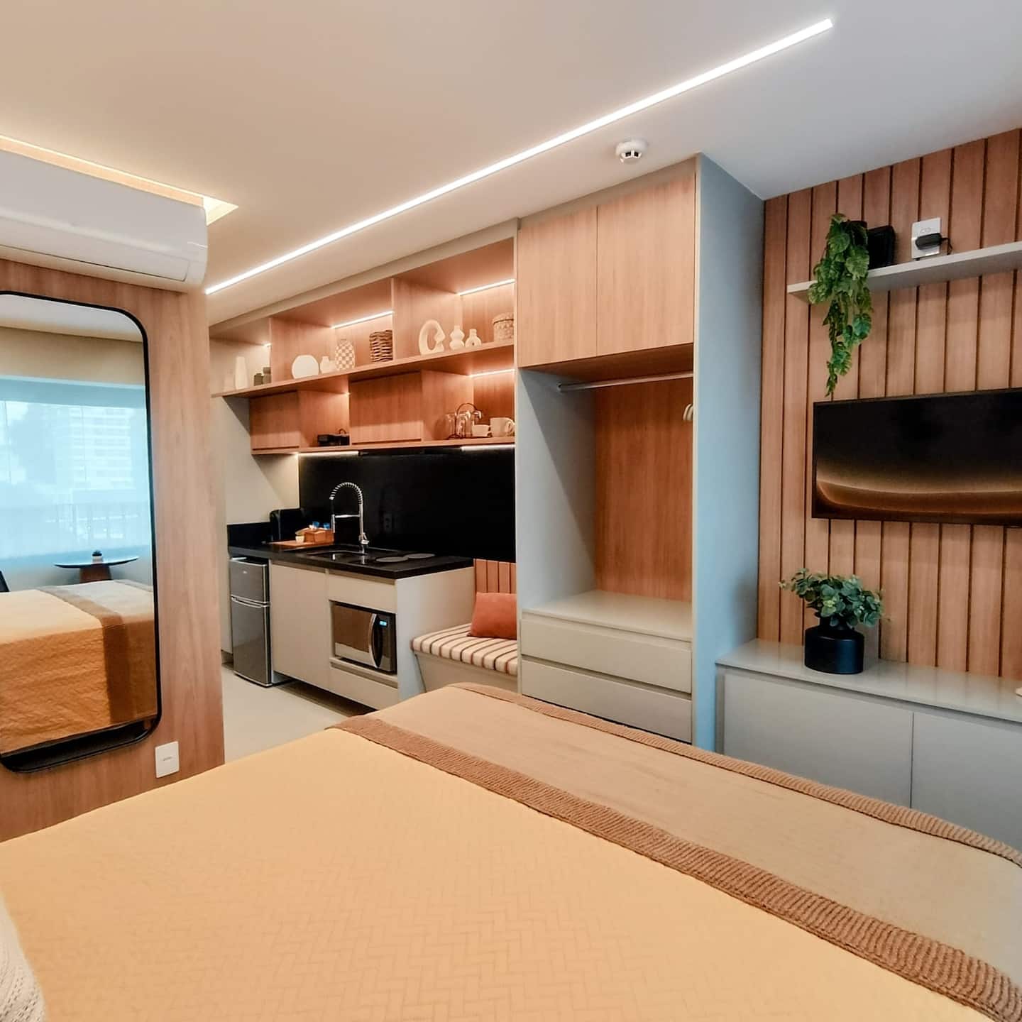Vista geral do studio EP209, com cama, cozinha integrada e área de estar