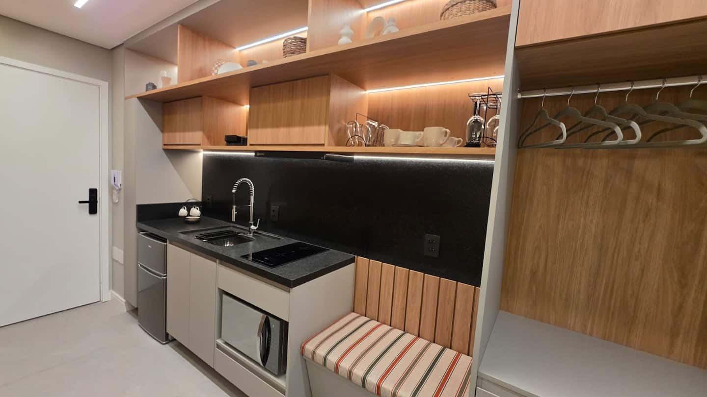 Cozinha com cabideiro e entrada do studio