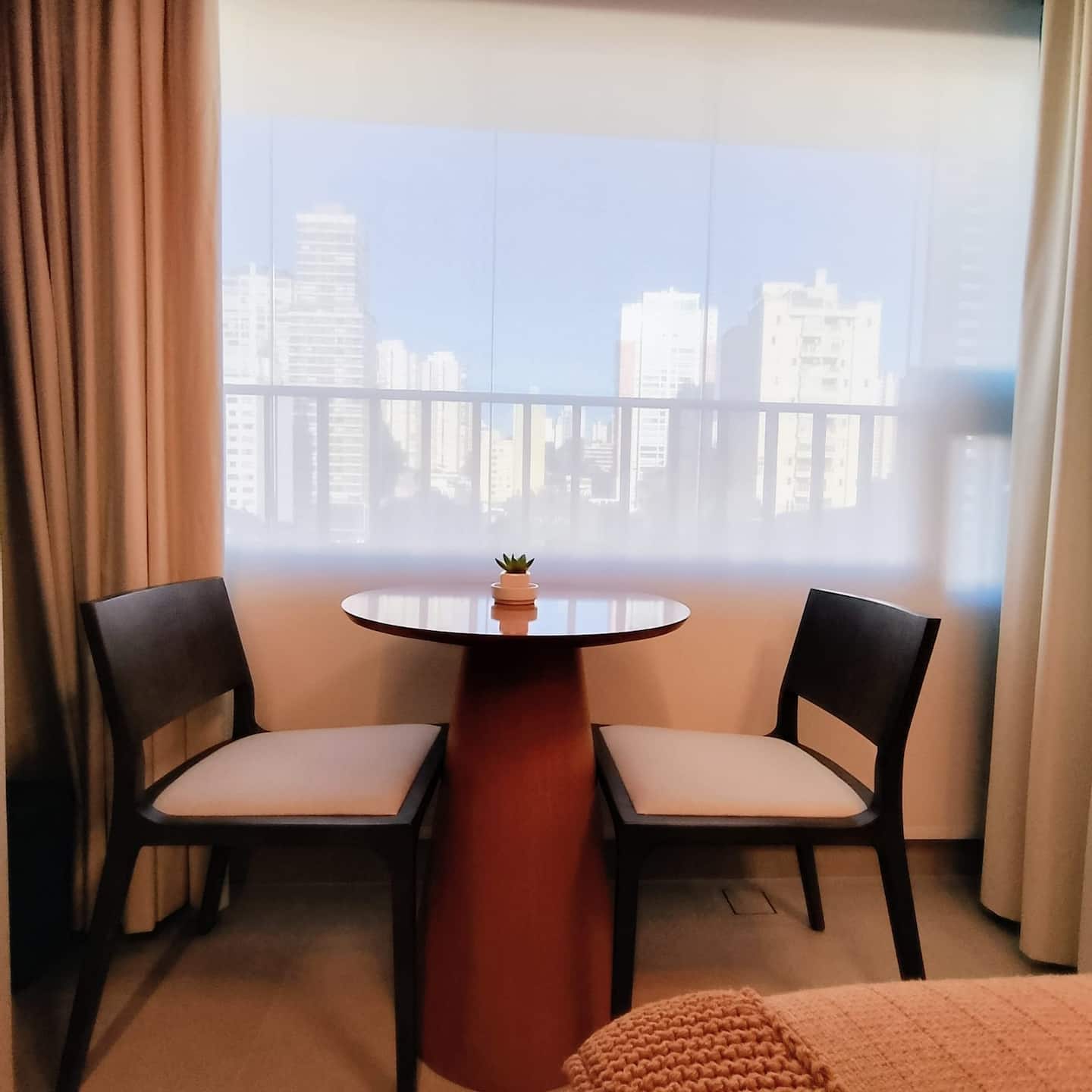 Mesa para refeições junto à janela com vista do skyline
