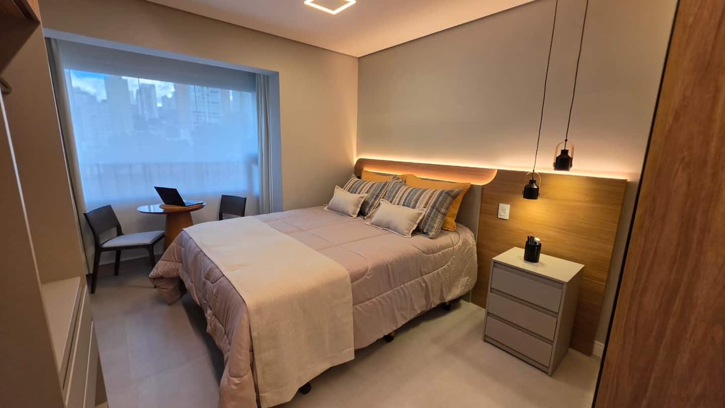 Quarto do studio com cama box Queen e vista para o bairro