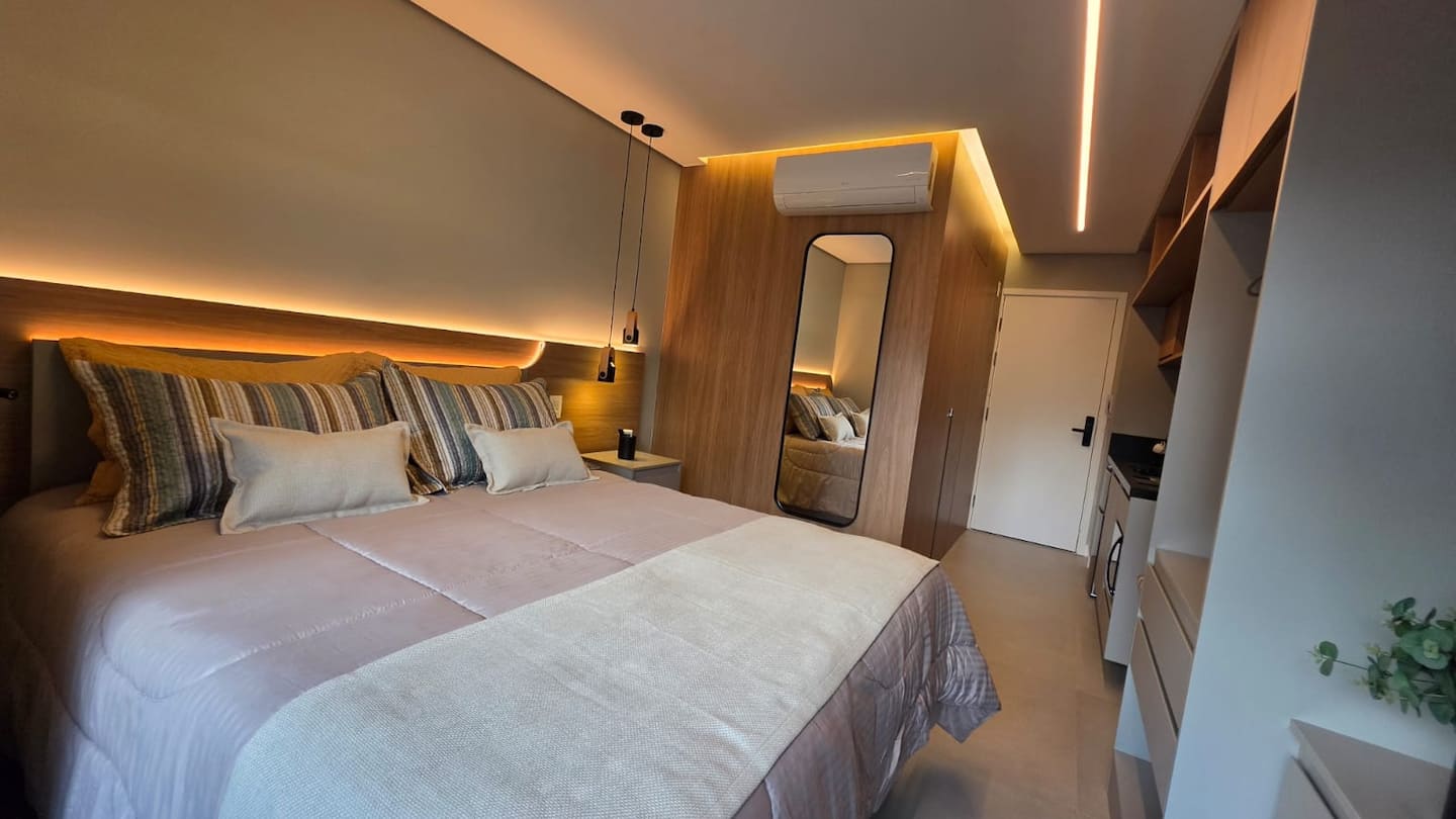 Quarto com espelho de corpo inteiro e ar-condicionado