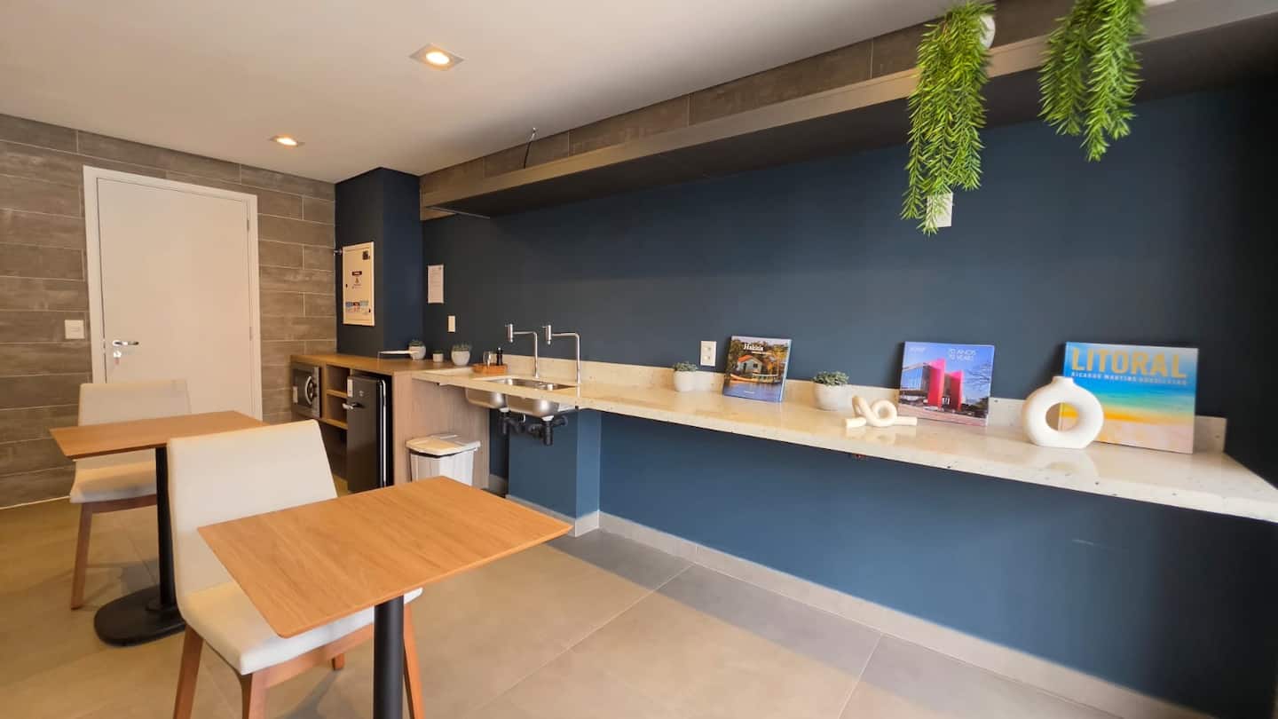 Espaço gourmet do condomínio, com cozinha e mesas para receber